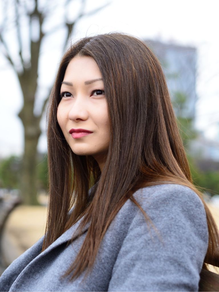 middle aged woman standing outside with contemplative gaze into the distance